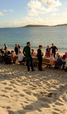 People sitting at a table on the beach, Isles of Scilly