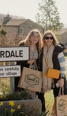Two people posing outside the Emmerdale sign on a tour