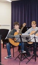 A group of people preparing to play guitars on stage as part of Oxford Music Festival