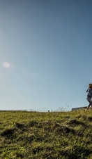 Two children playing in open space by a lighthouse