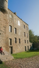 A woman sits on the steps of an historical property