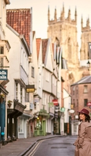 Woman wearing trench coat and pink hat walking