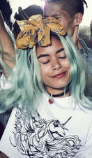 Girl with dyed hair, smiling, dancing with a group of people