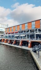 Red brick building next to tall office building beside canal