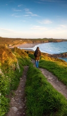 Walker on the Pembrokeshire coast path at Whitesands near St Davids, Wales