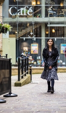 A woman and a man walk through a town centre