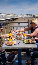 A family eating lunch next to the beach