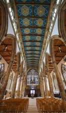 Looking up inside to the intricate ornate ceiling of an old church.