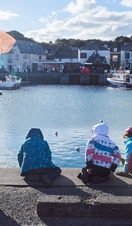 Children on harbour wall fishing for crabs