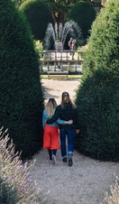 Male and female couple hugging in a garden near a fountain