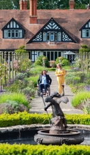 A woman and a man in a wheelchair smiling together in summer gardens