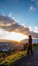 Man enjoying panoramic views of Edinburgh at the top of Arthur's Seat