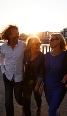 A group of people exploring the harbour of Cardiff at sunset