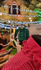 Close up of clothing on market stall at Victoria Baths with coloured lights in the background
