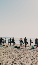 A yoga class being undertaken on a beach in Cornwall