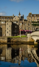 Historic buildings and houses line the Wick River