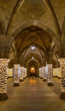 Fairy lights wrapped around pillars in a cloister at Glasgow University