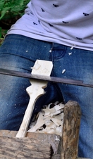 A person carving an object out of wood