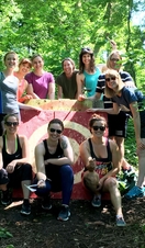A group of people posing in front of a target at an axe throwing range in Bristol