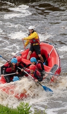 A group of people water rafting in waterproof safety gear