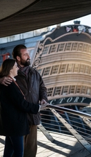 Two people looking over the bow of a ship