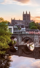 Roman Bridge over a river with a cathedral in background at sunrise