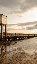 Two people by an elevated causeway at low tide 