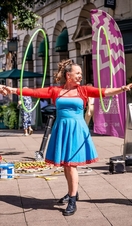 A performer with hula hoops outside as part of Norwich Summer Sessions