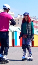 Two people rollerskating along the street in Brighton