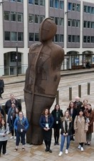 A tour group posing alongside a statue in Birmingham as part of a Positively Birmingham walking tour