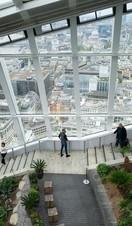 People walking down the stairs Sky Garden wth the city in the background