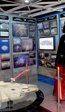 An actor in a Darth Vader costume in a Star Wars themed exhibit. 