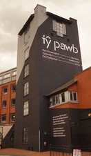 Exterior view of a building with a sign that reads 'Ty Pawb'.