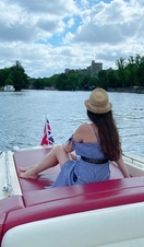 A woman sitting on a boat travelling down the River Thames in Windsor