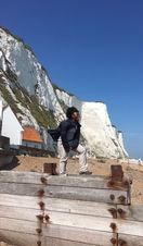 Woman, stood near white cliffs, looking out to sea