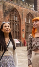 Two women explore the ruins within the grounds of a Cathedral