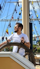 A man stood at a ship's wheel in the harbourside of Bristol