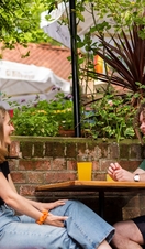Two people drinking at a table in Norwich Playhouse Gardens & Bar