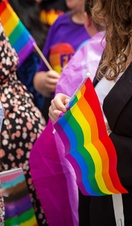 Crowds of people holding rainbow flags at the London Pride parade in London.
