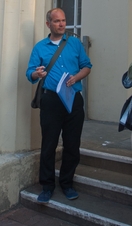A tour guide talking to a group outside a historic building in Brighton