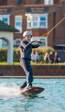 A woman water skiing and holding onto a line at Lagoon Watersports in Brighton