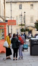Groups of people walking down a street in Bath's Upper City