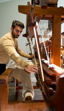 A man using a weaving loom during a workshop