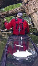 A man steering a kayak down a river in Oxford
