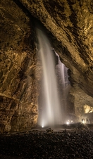 A waterfall falling through Gaping Gill in Yorkshire
