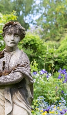 Lichen and moss covered statue at Crook Hall Gardens, County Durham