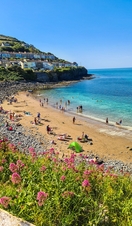 View of a bay with sandy beach and turquoise water with people