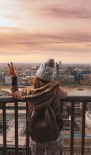 Woman at the top of St Paul's dome at sunrise with city view