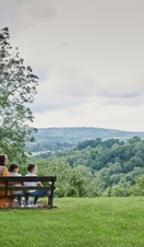 Family sit on a bench in park during summer
