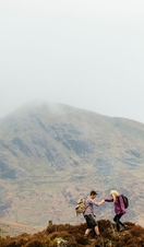 Couple hiking in the mountains on a cloudy day